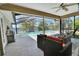 Screened in patio with seating area, grill, ceiling fan, and view of a pristine pool at 1963 Stacey Cir, Deltona, FL 32738