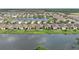 Beautiful lake view home with well-kept lawn, dark fenced yard, and a glimpse of the patio with seating at 214 Caryota Ct, New Smyrna Beach, FL 32168