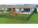 Aerial view of private backyard with playground, hot tub, and fenced yard perfect for outdoor entertainment at 214 Caryota Ct, New Smyrna Beach, FL 32168