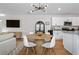 Modern dining area with a round table and contemporary light fixture, open to the kitchen at 214 Caryota Ct, New Smyrna Beach, FL 32168