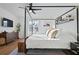 Serene main bedroom with a stylish canopy bed, modern decor, and large windows at 214 Caryota Ct, New Smyrna Beach, FL 32168