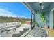 Screened patio with comfortable seating, and view of fenced backyard featuring lake, playground, and hot tub at 214 Caryota Ct, New Smyrna Beach, FL 32168