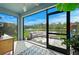 Enclosed patio with elegant outdoor seating, providing a view of the lake, playground, and lush landscape at 214 Caryota Ct, New Smyrna Beach, FL 32168