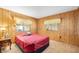 Cozy bedroom with wood paneling, a comfortable bed, and ample natural light at 24919 Drive No 1, Astor, FL 32102