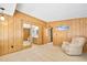 Bright bedroom with a large mirror, a comfortable recliner, and doorway to bathroom at 24919 Drive No 1, Astor, FL 32102