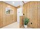 Inviting entryway with wood paneling, neutral tile flooring, and a decorative plant for a welcoming atmosphere at 24919 Drive No 1, Astor, FL 32102