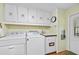 Functional laundry room with washer, dryer, sink, and ample storage space at 24919 Drive No 1, Astor, FL 32102