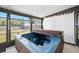 Enclosed sunroom features a hot tub and windows overlooking the surrounding yard at 24919 Drive No 1, Astor, FL 32102