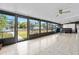 Spacious sunroom with tile flooring, fan, and expansive windows with backyard views at 24919 Drive No 1, Astor, FL 32102