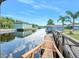 Scenic waterfront showcasing dock, lush palm trees, and serene canal access at 24919 Drive No 1, Astor, FL 32102