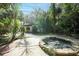 Lush backyard with patio and built in fire pit surrounded by tropical plants and trees at 26 E Kelly Park Rd, Apopka, FL 32712