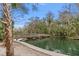 Scenic view of a wooden bridge over a tranquil river, surrounded by lush greenery and palm trees on a sunny day at 26 E Kelly Park Rd, Apopka, FL 32712