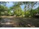 Expansive front yard features mature trees and natural landscaping at 26 E Kelly Park Rd, Apopka, FL 32712