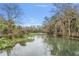 Picturesque view of a serene river with lush vegetation, showcasing the natural beauty of the surrounding landscape at 26 E Kelly Park Rd, Apopka, FL 32712