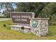 View of the Wekiwa Springs State Park sign, with stone base, set against a lush, green backdrop at 26 E Kelly Park Rd, Apopka, FL 32712