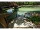 Outdoor stairs lead into pristine, clear water near a wooden bridge, surrounded by lush greenery at 26 E Kelly Park Rd, Apopka, FL 32712