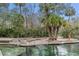 Easy water access with stairs and a sandy shore surrounded by lush greenery and clear waters at 26 E Kelly Park Rd, Apopka, FL 32712