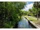 A scenic canal lined with greenery and trees offers a tranquil outdoor experience at 26 E Kelly Park Rd, Apopka, FL 32712