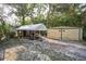 Outside view of metal sheds and open tent coverage in a grassy yard at 26 E Kelly Park Rd, Apopka, FL 32712