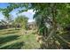 Spacious backyard featuring lush green grass, mature trees, and a pergola in a tranquil setting at 3228 Unity Tree Dr, Edgewater, FL 32141