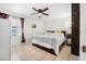 Bright bedroom featuring tile flooring, a ceiling fan, a large window, and a comfortable queen-size bed at 3228 Unity Tree Dr, Edgewater, FL 32141