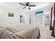 Bright bedroom with tile flooring, a ceiling fan, closet, a TV, and a comfortable queen-size bed at 3228 Unity Tree Dr, Edgewater, FL 32141
