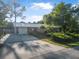 Charming home featuring a metal roof, lush landscaping, and an expansive driveway at 3228 Unity Tree Dr, Edgewater, FL 32141
