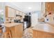 Functional kitchen with neutral cabinets, black appliances, and a cozy breakfast bar at 3228 Unity Tree Dr, Edgewater, FL 32141