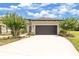 Charming home featuring a large driveway leading to a two-car garage, complemented by lush landscaping at 3329 Bailey Ann Dr, Ormond Beach, FL 32174