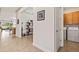 Welcoming hallway with tiled floors, decorative shelving, and convenient access to the laundry room at 3329 Bailey Ann Dr, Ormond Beach, FL 32174