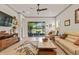 Bright living room with ceiling fan, beige sofa, patterned rug, and sliding door access to the patio at 3329 Bailey Ann Dr, Ormond Beach, FL 32174