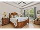 Primary bedroom with tray ceiling, queen-size bed, side tables, and large window at 3329 Bailey Ann Dr, Ormond Beach, FL 32174