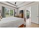 Primary bedroom with tray ceiling, queen-size bed, side tables, and large window at 3329 Bailey Ann Dr, Ormond Beach, FL 32174