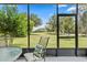 Inviting screened-in porch offering serene views of the lush green golf course and mature trees at 3329 Bailey Ann Dr, Ormond Beach, FL 32174