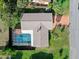 Aerial view of a home with a screened pool enclosure, green lawn, and mature landscaping at 354 Georgetown Dr, Daytona Beach, FL 32118
