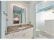 Bright bathroom features a modern vanity with granite countertop and a walk-in shower at 354 Georgetown Dr, Daytona Beach, FL 32118