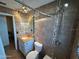 Bathroom with a granite countertop vanity, tiled shower, and modern lighting at 354 Georgetown Dr, Daytona Beach, FL 32118
