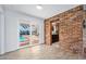 View of a bright room with a glass slider, exposed brick, and a glimpse into the kitchen at 354 Georgetown Dr, Daytona Beach, FL 32118