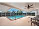Covered and screened pool featuring blue skies, palm trees, and comfortable seating area at 354 Georgetown Dr, Daytona Beach, FL 32118