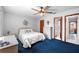 Comfortable bedroom with ceiling fan, closet, en suite bathroom, and soft blue carpeting at 3620 Cardinal Blvd # 80, Daytona Beach, FL 32118