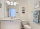 Well-lit bathroom with a single sink vanity and a pristine toilet at 3620 Tresto St, New Smyrna Beach, FL 32168