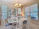 Sunlit dining room with modern white table set, display cabinet, and bright windows at 3620 Tresto St, New Smyrna Beach, FL 32168