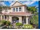 Charming two-story townhome features a covered front porch with seating and well-maintained landscaping at 3620 Tresto St, New Smyrna Beach, FL 32168