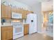 Efficient kitchen with appliances, wood cabinets, opening to dining room at 3620 Tresto St, New Smyrna Beach, FL 32168