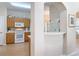 Charming kitchen with a breakfast bar, tile floors, white appliances, and light wood cabinetry at 3620 Tresto St, New Smyrna Beach, FL 32168