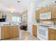 Well-lit kitchen showcasing wood cabinets and appliances with a view to the living room at 3620 Tresto St, New Smyrna Beach, FL 32168