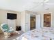 Bright main bedroom features a ceiling fan, a dresser, and a comfortable rocking chair at 3620 Tresto St, New Smyrna Beach, FL 32168