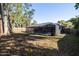 Spacious backyard with a screened-in pool, mature trees, and a wooden privacy fence at 464 Nash Ln, Port Orange, FL 32127