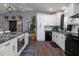 Kitchen features white cabinets, black stainless steel appliances, and wood flooring at 464 Nash Ln, Port Orange, FL 32127