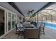 Covered outdoor patio with stylish seating and ceiling fans overlooking a screened-in pool area at 464 Nash Ln, Port Orange, FL 32127